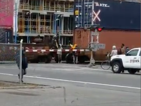 A screengrab from a video posted to Twitter shows people climbing over a CP Rail car at 11th St. and 9th Ave. S.W. on Nov. 2, 2018.