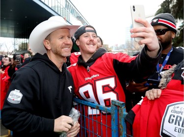 The Calgary Stampeders Head Coach Dave Dickenson signs autographs as thousands of fans turned out for a rally celebrating the Calgary Stampeders victory in the 106th Grey Cup outside city hall in Calgary on Tuesday, Nov. 27, 2018.