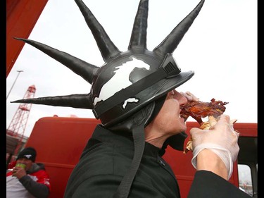 Chef Trevor Brubaker chows down on a bacon wrapped turker leg at a tailgate party before the CFL Western Final in Calgary at McMahon Stadium on Sunday, November 18, 2018. Jim Wells/Postmedia