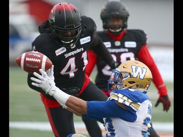 Winnipeg Blue Bombers RB Andrew Harris tries to lateral as he's tackled during the CFL Western Final in Calgary at McMahon Stadium on Sunday, November 18, 2018. Jim Wells/Postmedia