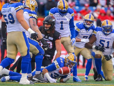 Winnipeg Blue Bombers Andrew Harris is tackled by Alex Singleton of the Calgary Stampeders during the 2018 CFL Western Final in Calgary on Sunday, November 18, 2018. Al Charest/Postmedia