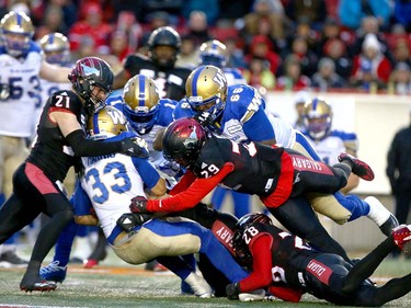 Winnipeg Blue Bombers RB Andrew Harris is gang tackled during the CFL Western Final in Calgary at McMahon Stadium on Sunday, November 18, 2018. Jim Wells/Postmedia