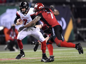 Calgary Stampeders defensive lineman Junior Turner tackles Ottawa Redblacks quarterback Trevor Harris during the first half of the 106th Grey Cup at Commonwealth Stadium in Edmonton, Sunday, Nov. 25, 2018.