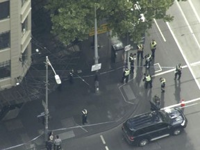 This image made from video shows police on street corner after a shooting in Melbourne, Australia, Friday, Nov. 9, 2018. Police shot a knife-wielding man Friday after he fatally stabbed one person and injured two others in the center of Australia's second-largest city, police said. (Australian Broadcasting Corporation via AP)