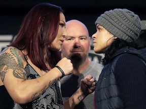 Cris Cybor, left, and Amanda Nunes face off while posing for a photographers during a news conference talking about their featherweight mixed martial arts bout, Friday, Nov. 2, 2018, at Madison Square Garden in New York. The two will fight in UFC 232, which is scheduled for Dec. 29, 2018, in Las Vegas.
