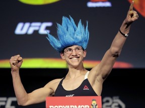 Roxanne Modafferi gestures while atop a scale during the weigh-ins ahead of her mixed martial arts flyweight bout against Sijara Eubanks at UFC 230, Friday, Nov. 2, 2018, at Madison Square Garden in New York. (AP Photo/Julio Cortez)