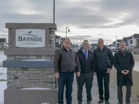 From left to right, Arnie Stefaniuk, Mayor Peter Brown, Iain Stewart, and Peter Jensen of Genesis Land Development Co. pose together on the new Bayside Estates bridge on Wednesday, Dec. 5. The new bridge will connect the north and south sides of the community for faster travel by pedestrians and vehicles. (Photo by Kelsey Yates/Airdrie Echo/Postmedia Network)