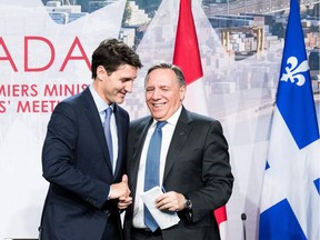 Prime minister of Canada Justin Trudeau (L) with premier of Quebec François Legault (R) shake hands during a meeting with Canadian prime ministers in Montreal, on December 7, 2018 at the Marriott Chateau Champlain.