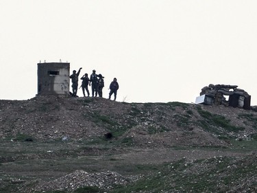 Fighters of People's Protection Units, or YPG, gather at their outpost west of the city of Kobani, northern Syria, Tuesday, Dec. 18, 2018. Turkey has vowed to launch a new offensive against YPG, which is the main component of a U.S.-allied force that drove Islamic State militants out of much of eastern Syria. U.S. troops are based in the area, in part to reduce tensions.
