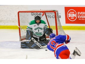 Okotoks Bow Mark Oilers goalie Gage Alexander makes a save on a shot by Ryan Shostak of the Calgary Buffaloes during the Mac's AAA hockey tournament at Max Bell Centre on Wednesday, December 26, 2018. Al Charest/Postmedia