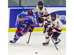 Calgary Buffaloes' Joel Homersham battles for the puck against Josh Romanyk of the Regina Pat Canadians during the Mac's AAA hockey tournament at Max Bell Centre on Thursday, December 27, 2018. Al Charest / Postmedia