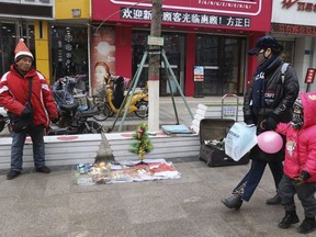 In this Saturday, Dec. 22, 2018, photo, a man sells Christmas decorations on a street of Zhangjiakou in northern China's Hebei province.