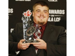 Calgary Stampeders Brett Jones, holds his trophy after winning the Most Outstanding Offensive Lineman award at the annual CFL player awards ahead of the 102nd Grey Cup in Vancouver, BC on Thursday November 27, 2014. Postmedia file photo