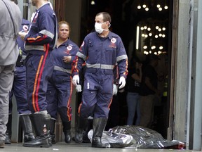 A firefighter walks next to a victim killed at the Metropolitan Cathedral in Campinas, Brazil, Tuesday, Dec.11, 2018. Authorities say an armed man entered the cathedral in southern Brazil on Tuesday afternoon and opened fire, killing at least four people before killing himself.