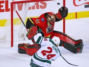 Calgary Flames goaltender Mike Smith deflects a slap shot by the Minnesota Wild's Matt Dumba during NHL action at Scotiabank Saddledome in Calgary on Thursday, Dec. 6, 2018.