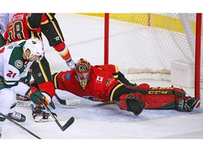 Calgary Flames goaltender Mike Smith stops this Minnesota Wild scoring chance with the Wild's Eric Fehr during NHL action at the Scotiabank Saddledome in Calgary on Thursday December 6, 2018.