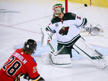 The Calgary Flames' Elias Lindholm scores on Minnesota Wild goaltender Alex Stalock during NHL action at the Scotiabank Saddledome in Calgary on Thursday December 6, 2018.