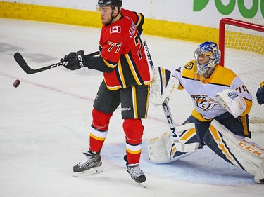 The Calgary Flames' Mark Jankowski swings for a flying puck in front of Nashville Predators goaltender Juuse Saros during NHL action at the Scotiabank Saddledome in Calgary on Saturday December 8, 2018.