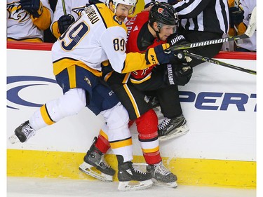 The Nashville Predators' Frederick Gaudreau and the Calgary Flames' Austin Czarnik collide along the boards during NHL action at the Scotiabank Saddledome in Calgary on Saturday December 8, 2018.