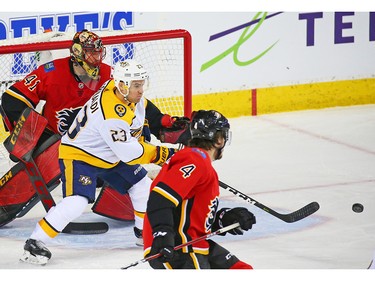 The Nashville Predators' Rocco Grimaldi tracks the puck in front of Calgary Flames goaltender Mike Smith in NHL action at the Scotiabank Saddledome in Calgary on Saturday December 8, 2018.
