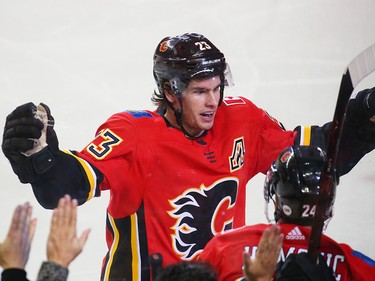 The Calgary Flames Sean Monahan celebrates assisting on Oliver Kylington's first NHL on Nashville Predators goaltender Juuse Saros during NHL action at the Scotiabank Saddledome in Calgary on Saturday December 8, 2018.