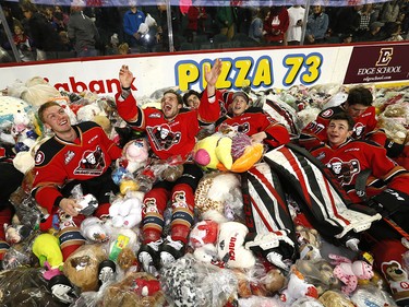Calgary Hitmen Kaden Elder celebrates with teammates after scoring on Kamloops Blazers goalie Dylan Garand to start the bear toss during the 24th annual Brick Teddy Bear Toss game at the Scotiabank Saddledome in Calgary on Sunday December 9, 2018.