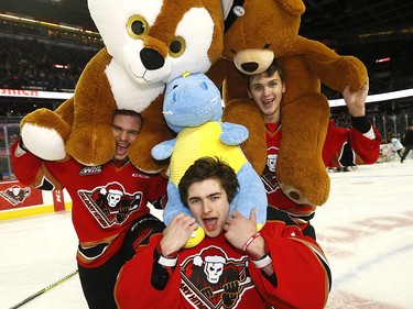 Calgary Hitmen Kaden Elder celebrates with teammates Jack McNaughton and Egor Zamula after scoring on Kamloops Blazers goalie Dylan Garand to start the bear toss during the 24th annual Brick Teddy Bear Toss game at the Scotiabank Saddledome in Calgary on Sunday December 9, 2018.