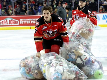Calgary Hitmen Hunter Campbell bags up bears during the 24th annual Brick Teddy Bear Toss game against the Kamloops Blazers at the Scotiabank Saddledome in Calgary on Sunday December 9, 2018.