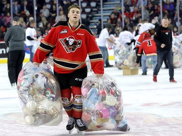 Calgary Hitmen Cael Zimmerman bags up bears during the 24th annual Brick Teddy Bear Toss game against the Kamloops Blazers at the Scotiabank Saddledome in Calgary on Sunday December 9, 2018.
