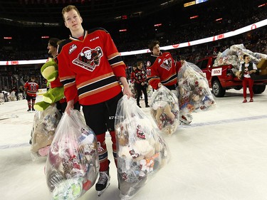 Calgary Hitmen Luke Prokop bags up bears during the 24th annual Brick Teddy Bear Toss game against the Kamloops Blazers at the Scotiabank Saddledome in Calgary on Sunday December 9, 2018.
