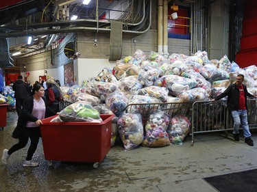 Volunteers move bags of bears to the loading dock during the Calgary Hitmen's 24th annual Brick Teddy Bear Toss game against the Kamloops Blazers at the Scotiabank Saddledome in Calgary on Sunday December 9, 2018.