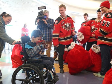 Calgary Hitmen players hand out teddy bears to kids at the Alberta Children's Hospital Monday, December 10, 2018. The team distributed some of the thousands of bears collected at Sunday's annual Brick Teddy Bear Toss game.