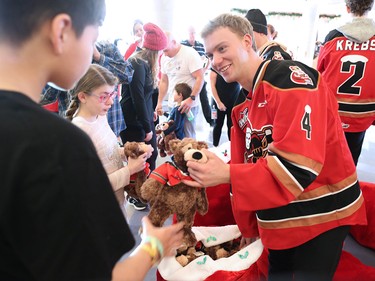 Calgary Hitmen defenceman Layne Toder hands out teddy bears to kids at the Alberta Children's Hospital Monday, December 10, 2018. Hitmen players distributed some of the thousands of bears collected at Sunday's annual Brick Teddy Bear Toss game.
