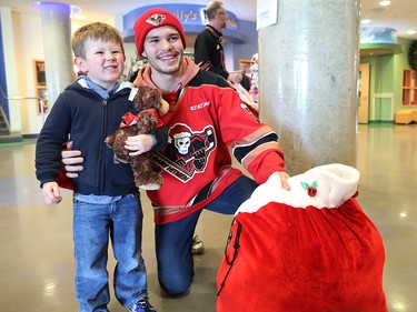 Calgary Hitmen forward Kaden Elder poses with Titan Sander, 4, after giving him a teddy bear at the Alberta Children's Hospital Monday, December 10, 2018. Hitmen players distributed some of the thousands of bears collected at Sunday's annual Brick Teddy Bear Toss game. Elder scored the first goal in the game to trigger the avalanche of stuffies.