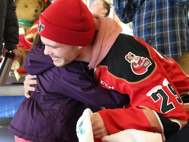 Calgary Hitmen forward Kaden Elder gets a hug from Arya Bagnriol, 4, after giving her a teddy bear at the Alberta Children's Hospital Monday, December 10, 2018. Hitmen players distributed some of the thousands of bears collected at Sunday's annual Brick Teddy Bear Toss game. Elder scored the first goal in the game to trigger the avalanche of stuffies.
