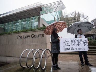 Supporters hold a sign outside B.C. Supreme Court during the third day of a bail hearing for Meng Wanzhou, the chief financial officer of Huawei Technologies, in Vancouver, on Tuesday December 11, 2018.