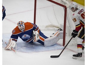 Edmonton Oilers goalie Mikko Koskinen (19) tries to get control of the puck as Calgary Flames Sam Bennett (93) watches during second period NHL action on Sunday, Dec. 9, 2018, in Edmonton.