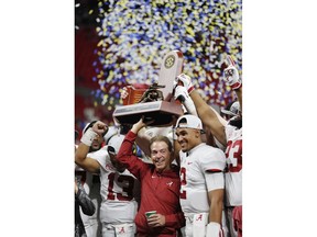 Alabama head coach Nick Saban and Alabama quarterback Jalen Hurts, right, celebrate with the team after the Southeastern Conference championship NCAA college football game against Georgia, Saturday, Dec. 1, 2018, in Atlanta. Alabama won 35-28.