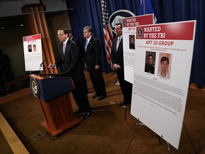 (L-R) U.S. Deputy Attorney General Rod Rosenstein speaks as FBI Director Christopher Wray and Assistant Attorney General for National Security John Demers listen during a news conference to announce a China related national security law enforcement action Dec. 20, 2018 in Washington, D.C. The Justice Department has filed charges against two Chinese national individuals, Zhu Hua and Zhang Shilong who believed to be associated with the Chinese Ministry of State Security, with conspiracy to commit computer intrusions, conspiracy to commit wire fraud, and aggravated identity theft.
