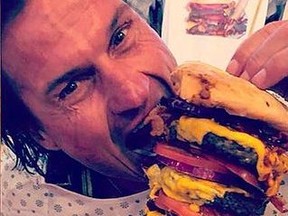 Norwegian hotel mogul Petter Stordalen holds a slider, left, and an Octuple Bypass Burger from the Heart Attack Grill in Vegas.(Instagram)