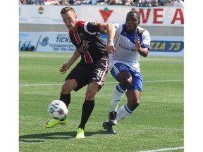 Then with Ottawa Fury FC, forward Oliver Minatel gets a foot on a cross crease pass while being challenged by a player from FC Edmonton during NASL action in Fort McMurray on Aug. 2, 2015. Minatel has signed on with Cavalry FC. Postmedia Network file photo.