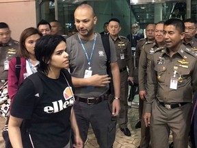 In this Jan. 7, 2019, file photo released by the Immigration Bureau, Saudi woman Rahaf Mohammed Alqunun, foreground, walks by Chief of Immigration Police Maj. Gen. Surachate Hakparn, right, before leaving the Suvarnabhumi Airport in Bangkok, Thailand. (Immigration police via AP, File)