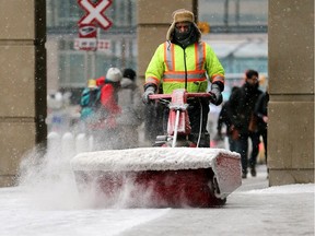 Snow is cleared from the sidewalk outside the Calgary Courts Centre on Thursday, January 17, 2019.