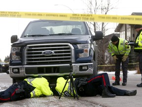 Police examine a pickup truck which struck a woman as she was walking her dog at the intersection of 5th Street and 26th Avenue N.W. on Wednesday, Jan. 9, 2018.