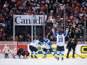 Canada goalie Michael DiPietro, left, kneels on the ice and Cody Glass, far right, looks down as Finland's Henri Jokiharju, Toni Utunen and Aleksi Heponiemi celebrate their winning goal during overtime quarterfinal IIHF world junior hockey championship action in Vancouver on Wednesday, Jan. 2, 2019.