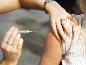 A person gets a shot during a flu vaccine program in Calgary on Oct. 26, 2009. THE CANADIAN PRESS/Jeff McIntosh ORG XMIT: CPT103 ORG XMIT: POS1802011010592107 ORG XMIT: POS1802120312557403