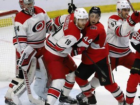 Ottawa Senators' Jean-Gabriel Pageau (44) battles for position with Carolina Hurricanes' Dougie Hamilton (19) in front of Hurricane goaltender Petr Mrazek (34) during third period NHL hockey play in Ottawa on Sunday, January 6, 2019. THE CANADIAN PRESS/Fred Chartrand