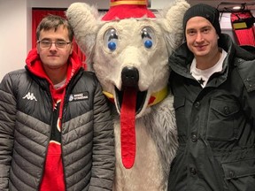 Brothers Tomas and David Rittich with Harvey The Hound (Photo from the Calgary Flames website)
