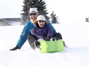 Pedro Guerra-Zuniga and Genevieve Kenny have a blast tobogganing down St. Andrews hill as the mild weather is back in Calgary on Sunday January 20, 2019.