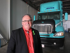 Transportation Minister Brian Mason stands in front of a training cab at the Alberta Motor Transport Association in Calgary on July 10, 2018.